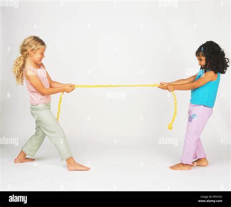 2 girls pulling a rope|Two girls pulling on either end of rope Stock Photo